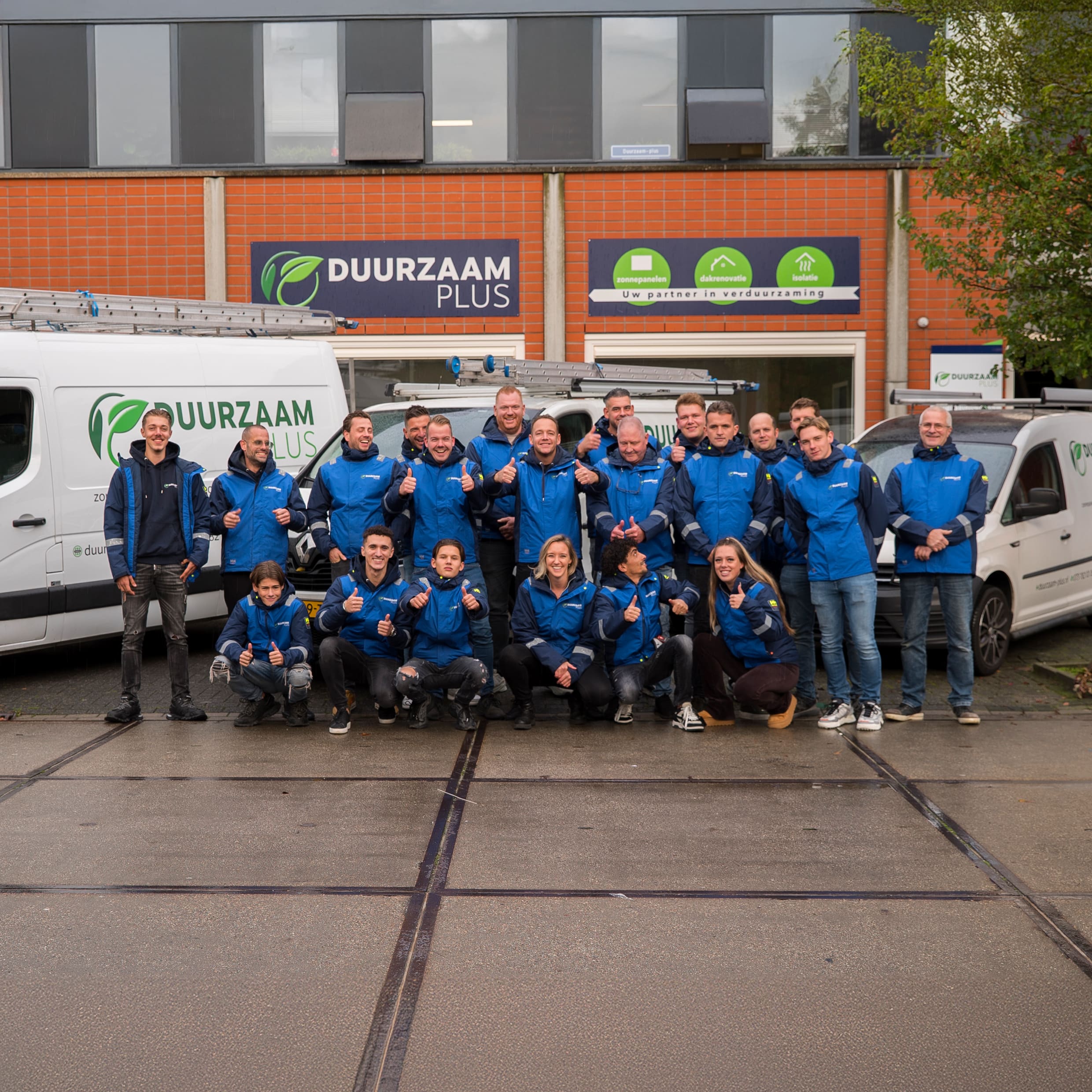 Het team van Duurzaam Plus in een regenjas, klaar om schade/lekkages aan een dak te repareren.